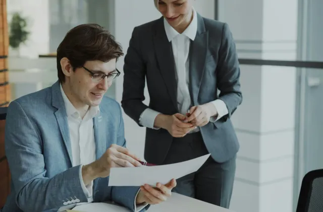 Two professionals reviewing documents together at a table
